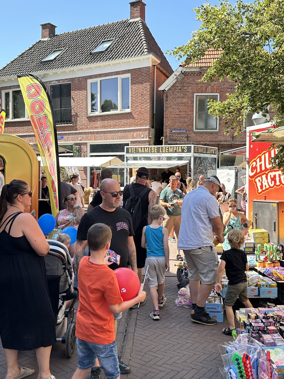 Bezoekers wandelen langs kramen en verkoopwagens