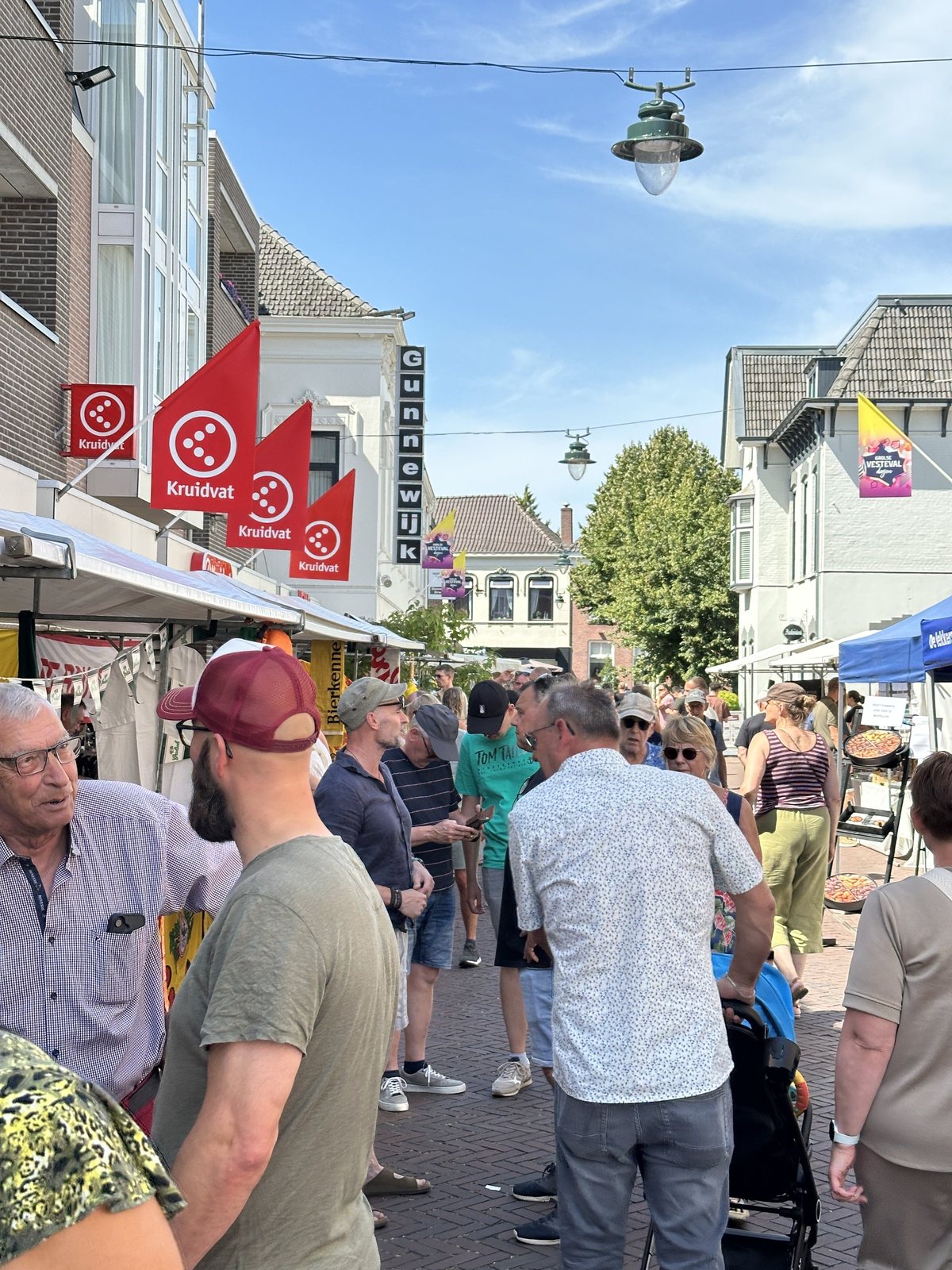 Een drukbezochte marktstraat op een zonnige dag