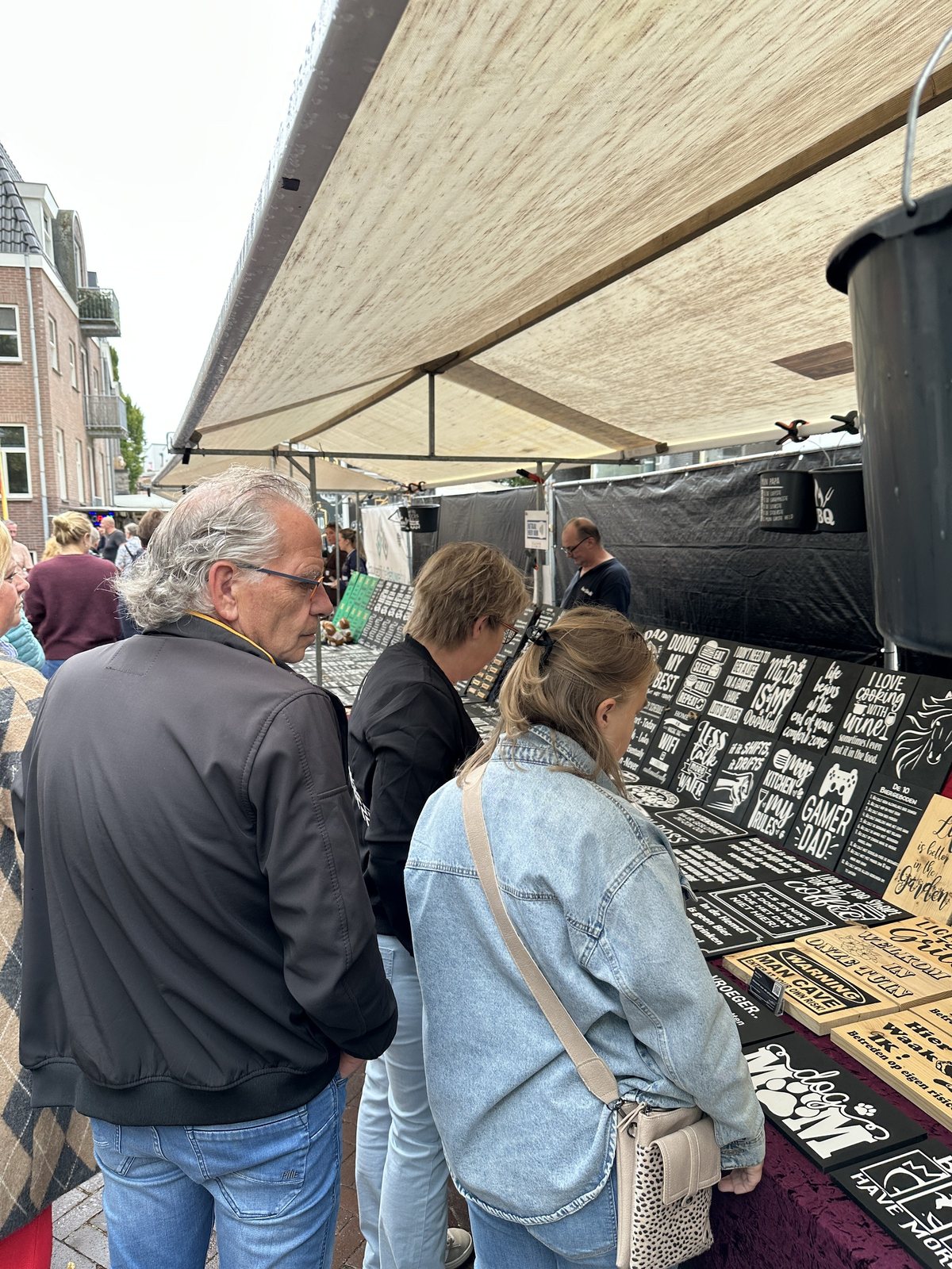 Bezoekers bekijken sieraden aan een marktkraam
