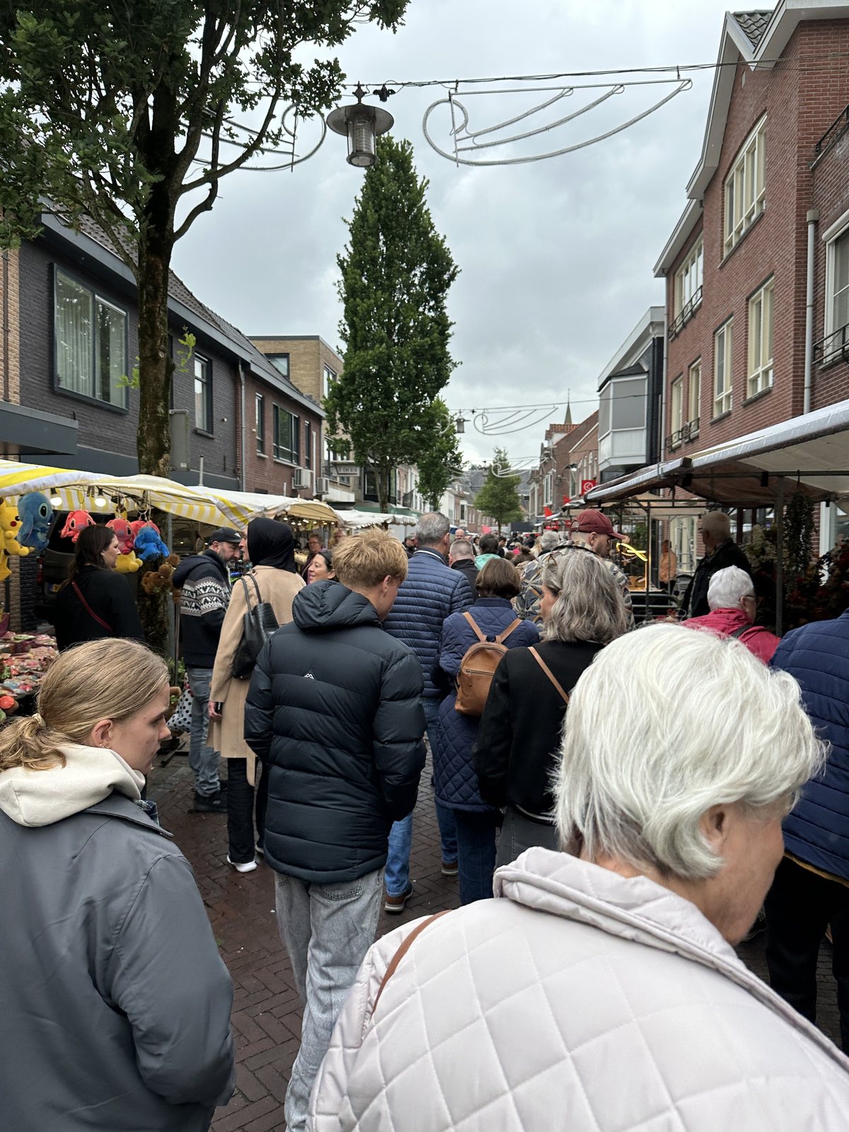 Een marktstraat met bezoekers en marktkramen