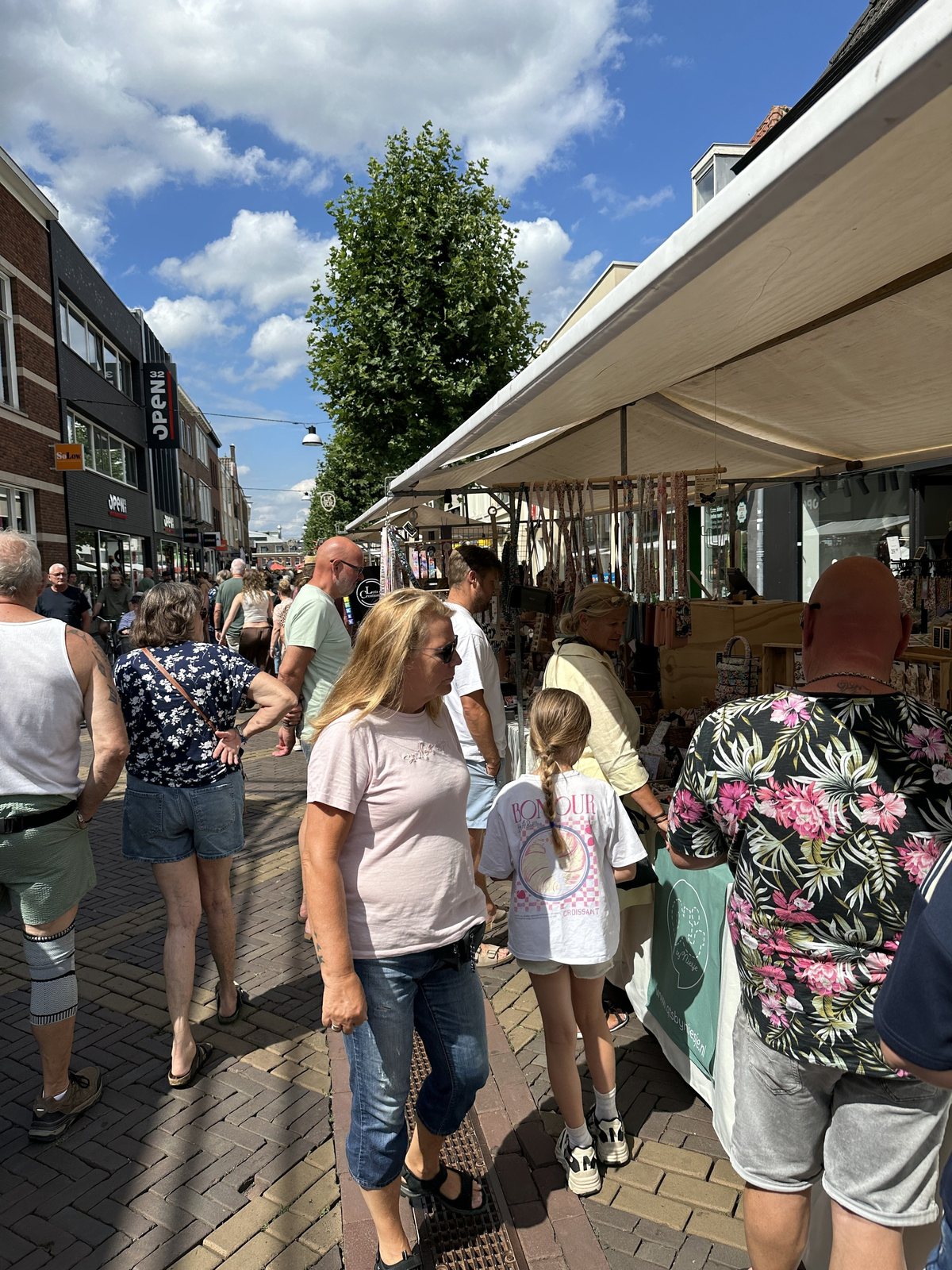 Bezoekers lopen langs de marktkramen op een zonnige dag